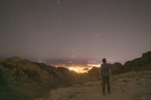 Man standing on overlook of city at night