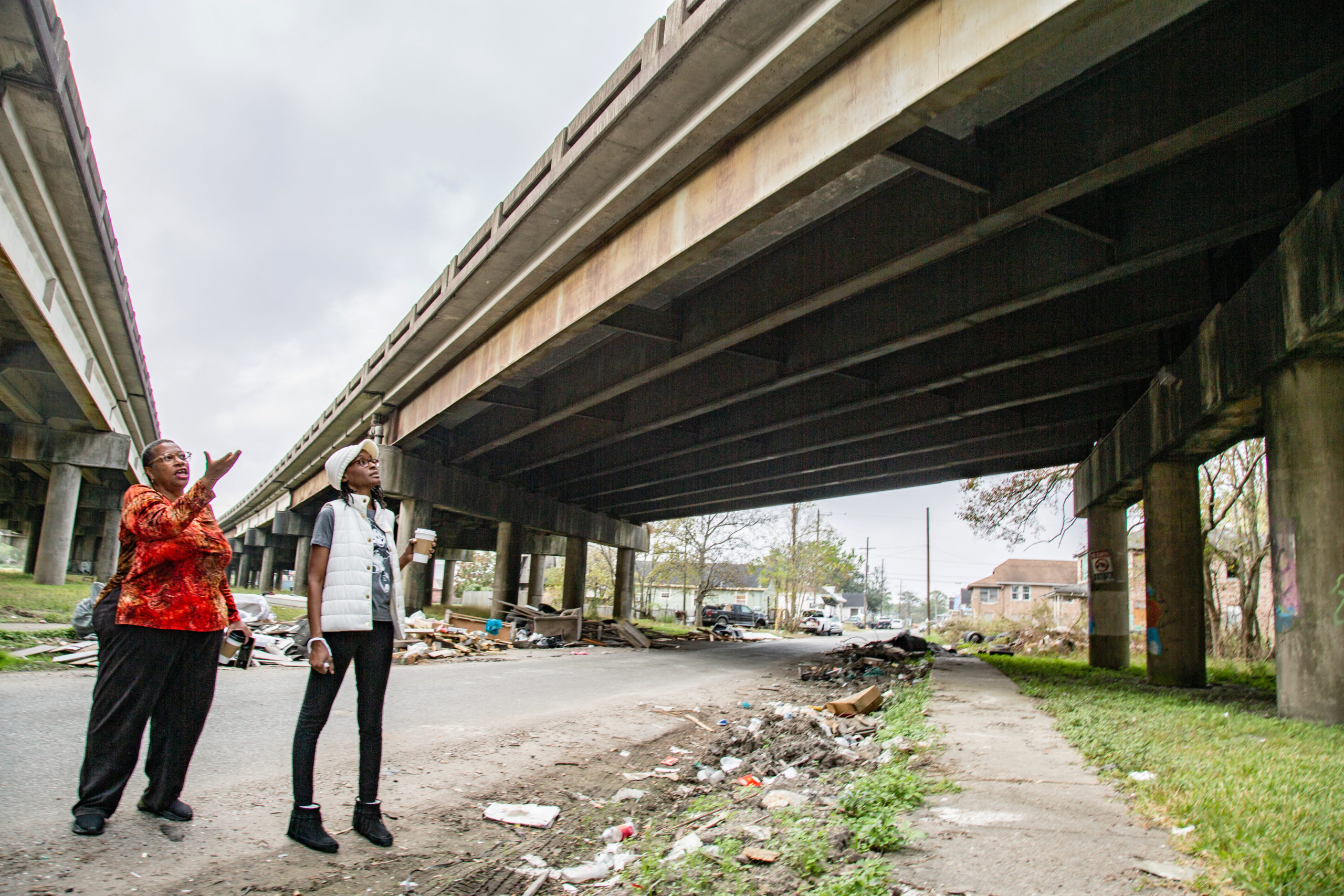 From left: Community leads Amy Stelly and Tamah Yisrael of the Claiborne Avenue Alliance stand at the highway I-10 overpass in Tamah’s neighborhood in the 7th Ward.