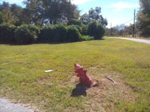 fire hydrant in a grassy area that is leaning to one side