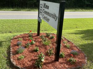 sign reading &quot;Mims Community Center&quot; in a small flower bed
